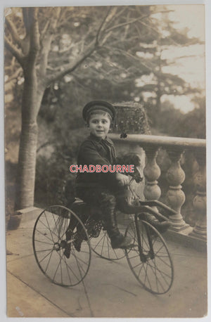 Vintage French postcard of young boy on his tricycle