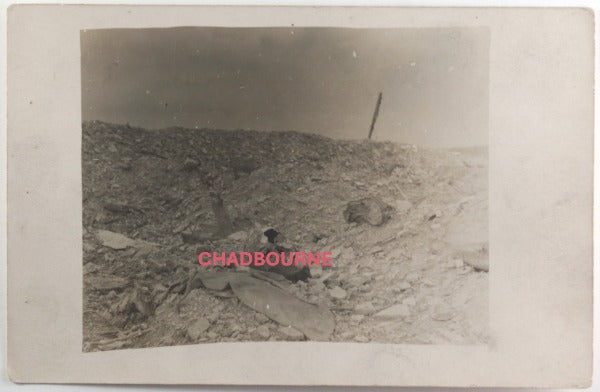 WW1 French photo postcard of a bleak battlefield with a KIA skull