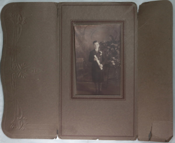 Early 1900s B&W studio photo of young boy in suit, holding certificate