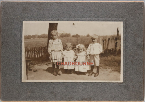 Early outdoor photo of four brothers and sisters at farm