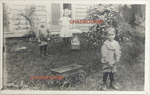 Photo postcard of 3 children with their toys c. 1910s