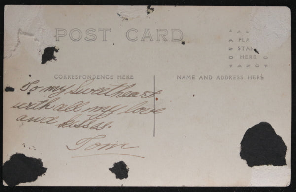 Photo postcard of US sailor in front of ship’s guns c.1919