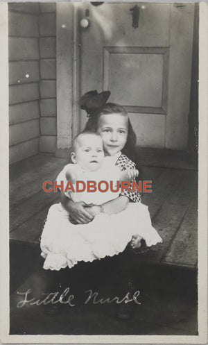 Photo postcard of young girl holding her baby sibling Canada c. 1920s