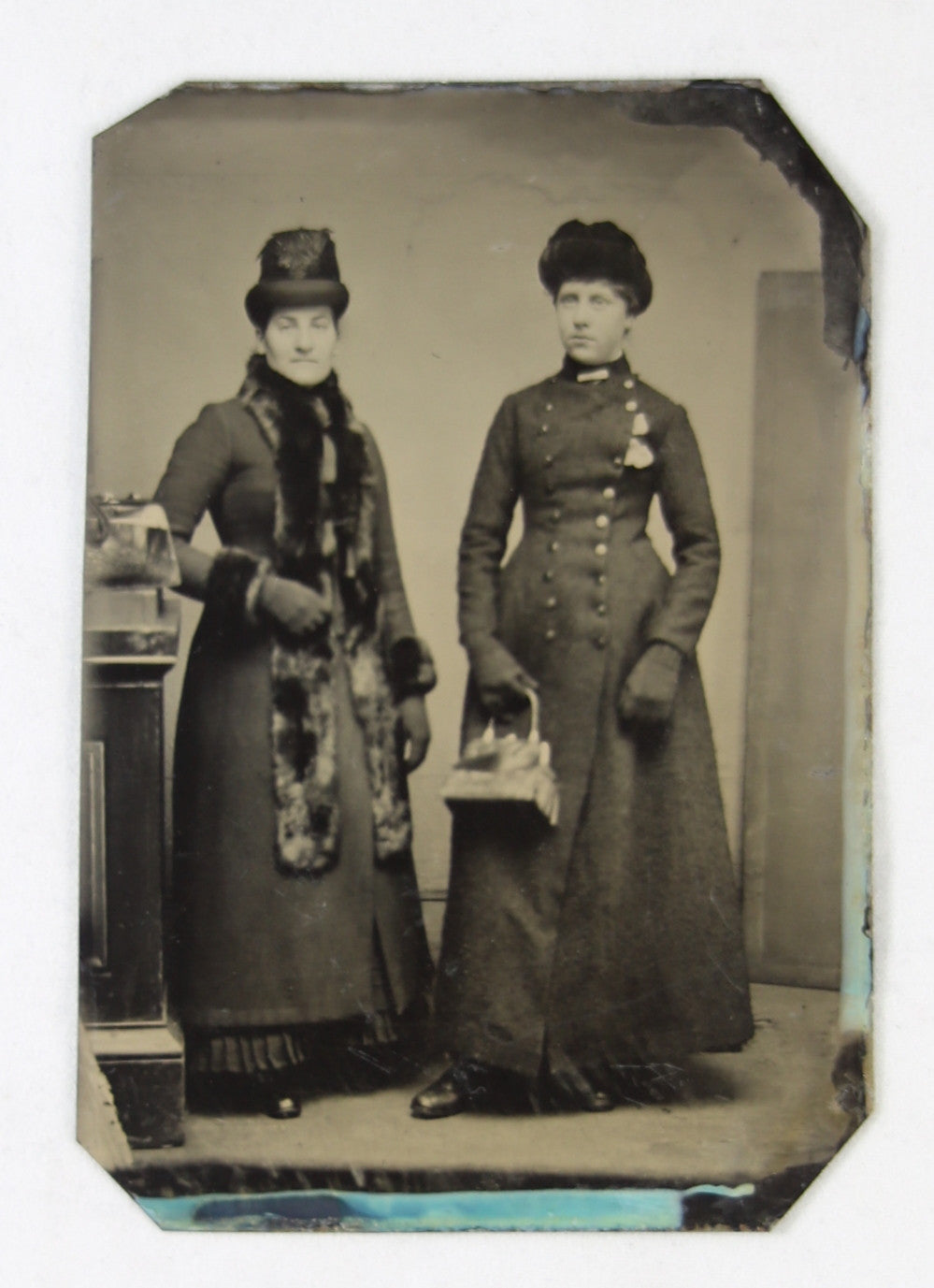 Tintype photo of two ladies dressed for the cold, late 1800s