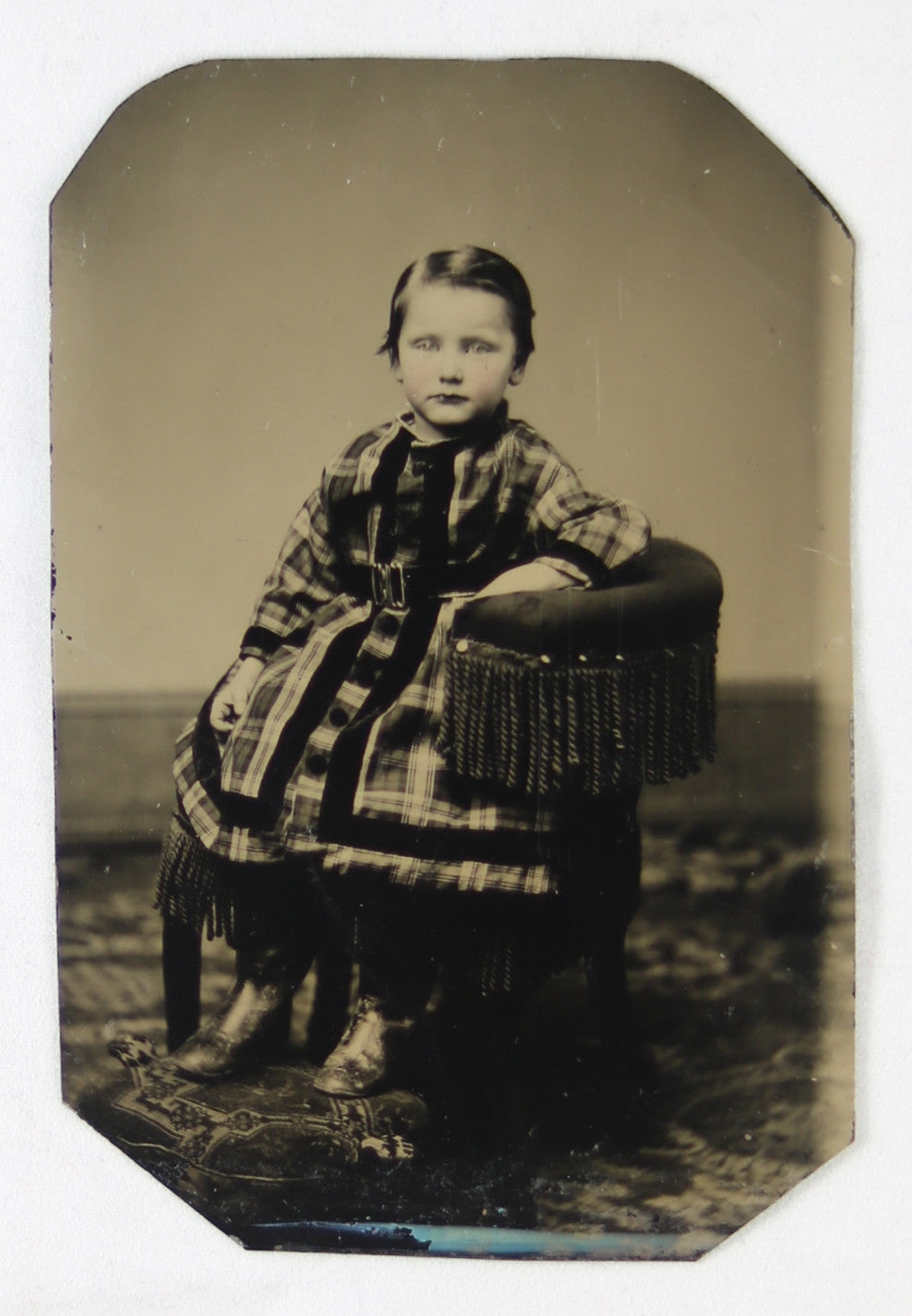 Tintype photo of young girl sitting in chair, late 1800s
