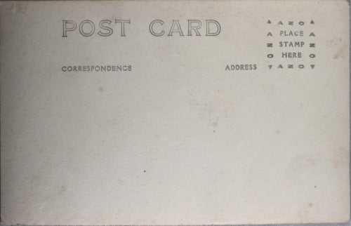 WW1 postcard photo of German soldier sitting front of homemade shelter