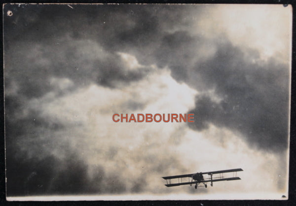 WW1 photo of a biplane in flight, coming out of clouds