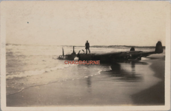 WW2 photo German soldier standing on plane crashed on beach France()